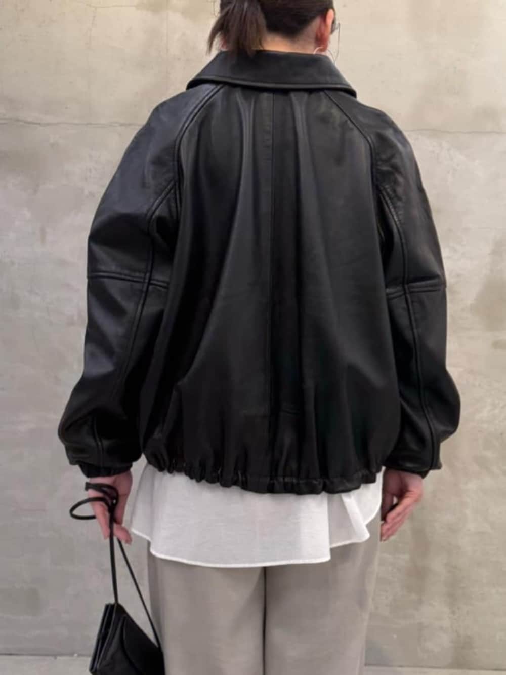 グレー系のその他パンツ、ブラック系のブルゾン、ホワイト系のシャツ/ブラウスを着用したレディースの冬コーディネートの6枚目の写真