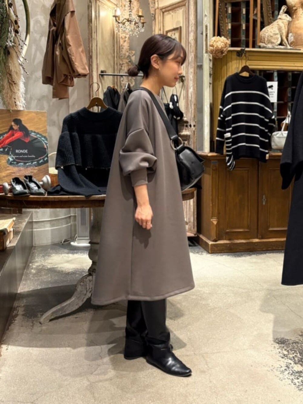 ブラウン系のワンピース、ブラック系のショルダーバッグ、シルバー系のネックレスを着用したレディースの冬コーディネートの5枚目の写真