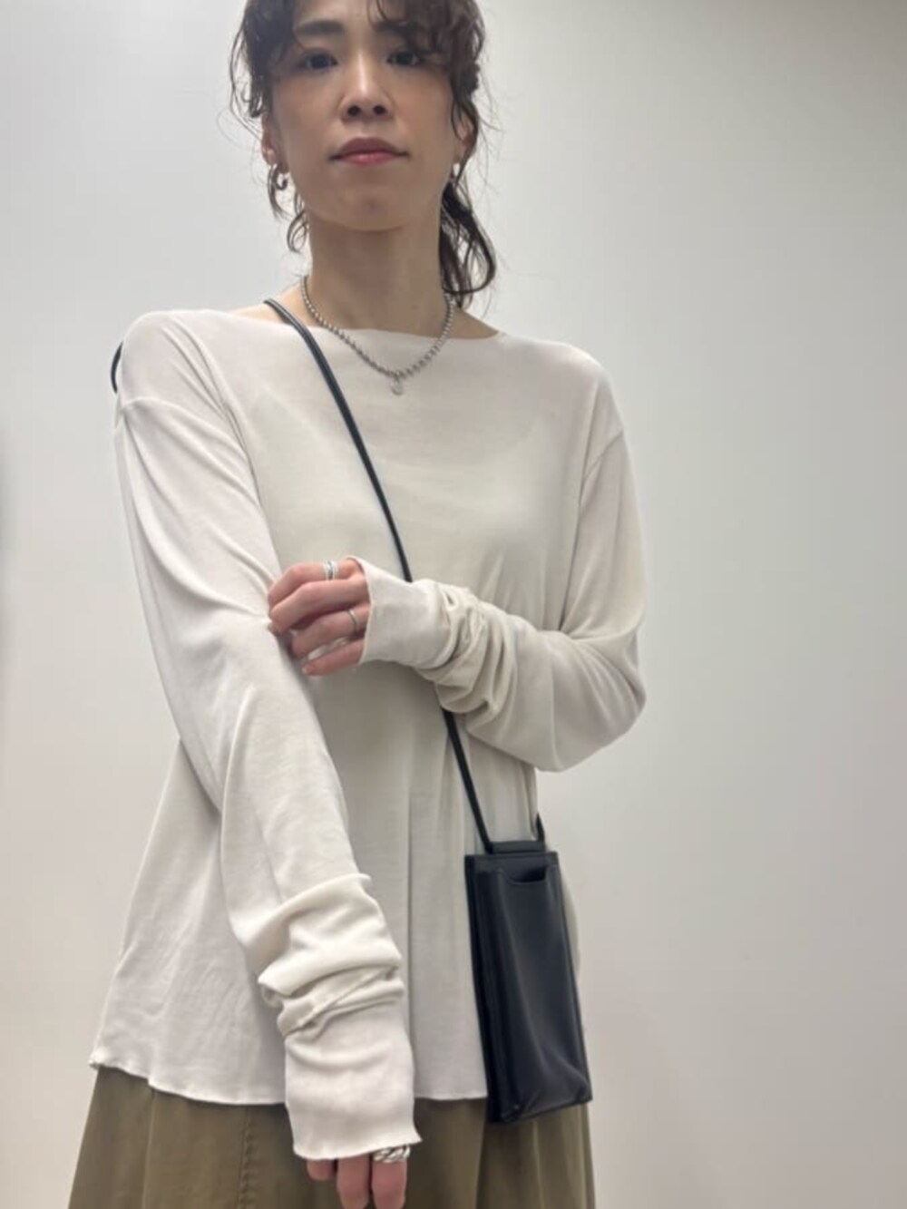 ブラック系のショルダーバッグ、イエロー系のその他パンツ、ホワイト系のTシャツ/カットソーを着用したレディースの春コーディネートの5枚目の写真