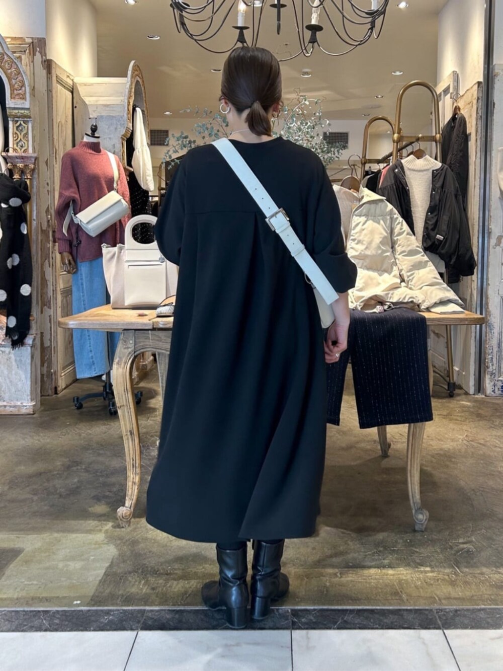 ホワイト系のショルダーバッグ、ブラック系のワンピースを着用したレディースの冬コーディネートの6枚目の写真