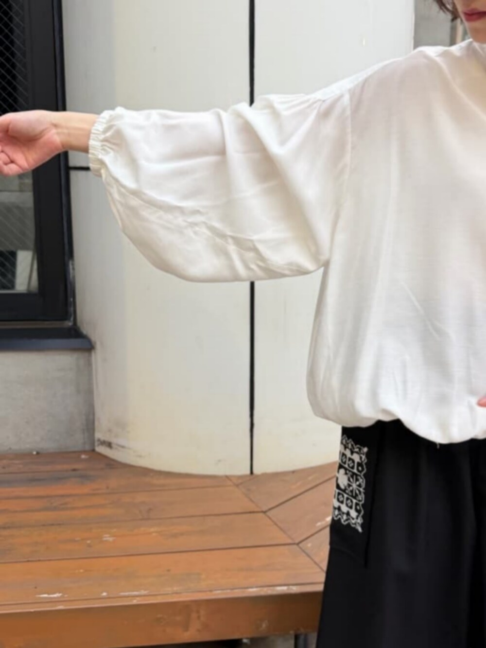 ホワイト系のシャツ/ブラウス、ブラック系のその他パンツ、ブラック系のブーツを着用したレディースの秋コーディネートの6枚目の写真