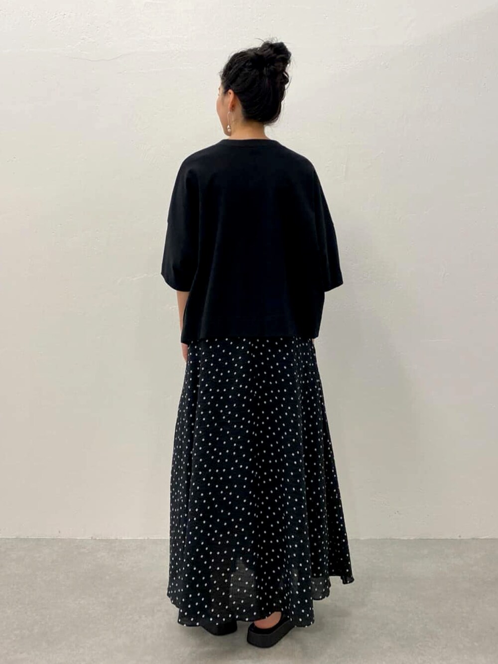 ブラック系のTシャツ/カットソー、ブラック系のスカートを着用したレディースの春コーディネートの3枚目の写真