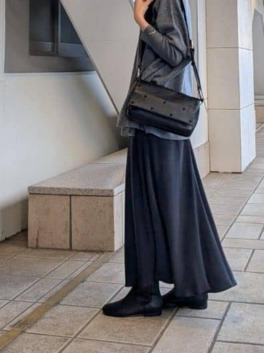 ブラック系のスカート、グレー系のニット/セーター、ブラック系のショルダーバッグを着用したレディースの冬コーディネートの5枚目の写真