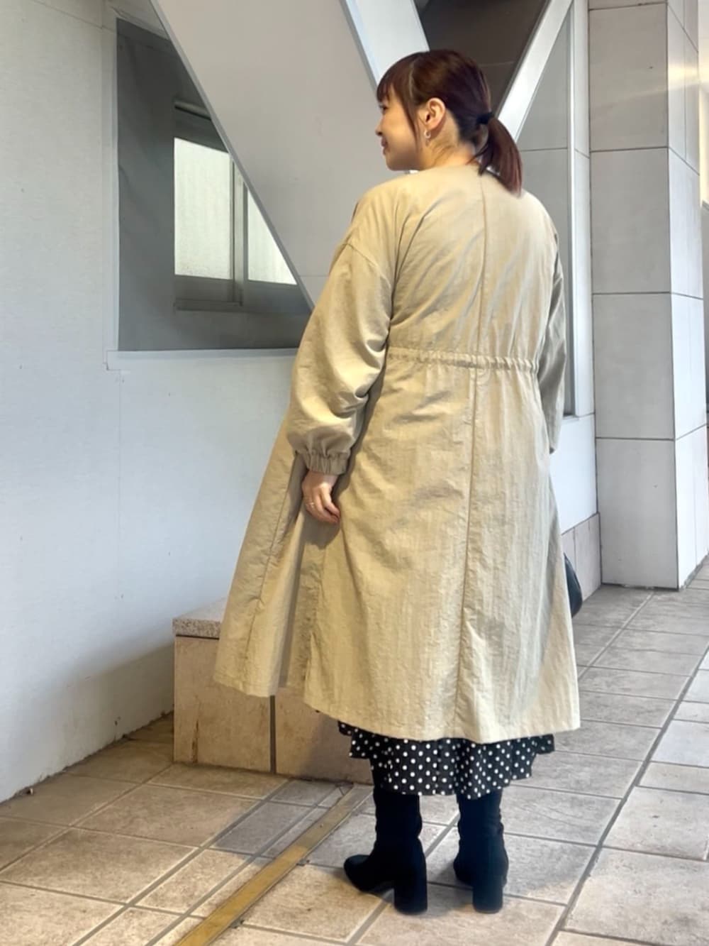 ベージュ系のその他アウター、ブラック系のワンピースを着用したレディースの冬コーディネートの6枚目の写真