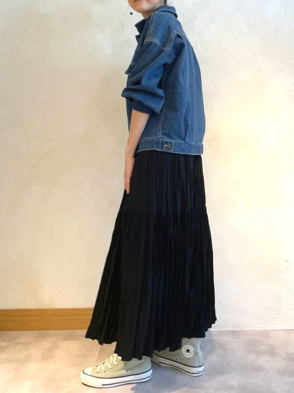 ブルー系のデニムジャケット、ブラック系のスカート、ホワイト系のかごバッグを着用したレディースの春コーディネートの2枚目の写真