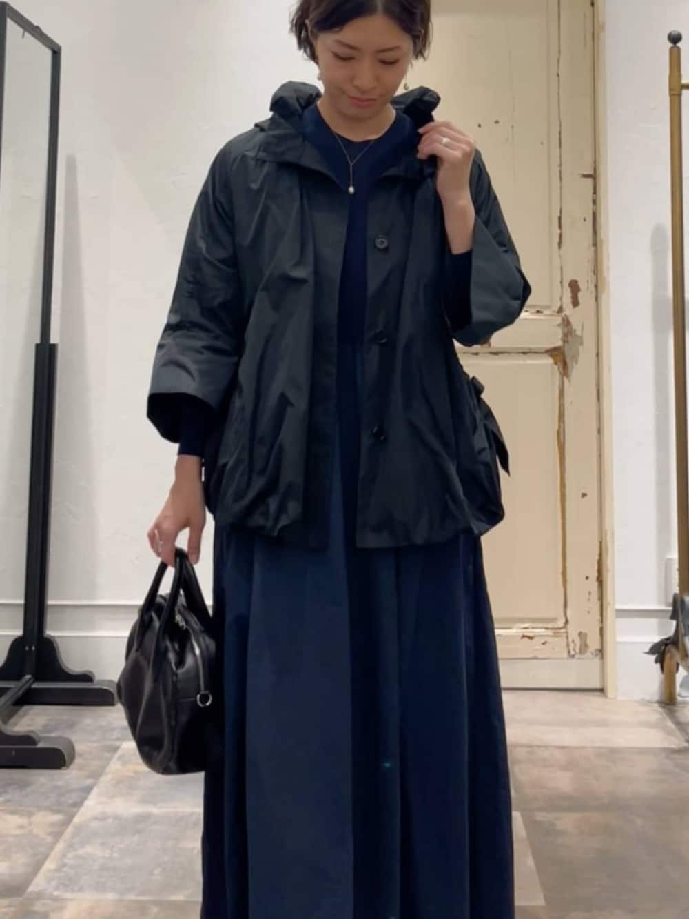 ブラック系のボストンバッグ、ブラック系のブルゾン、ブルー系のワンピースを着用したレディースの冬コーディネートの4枚目の写真