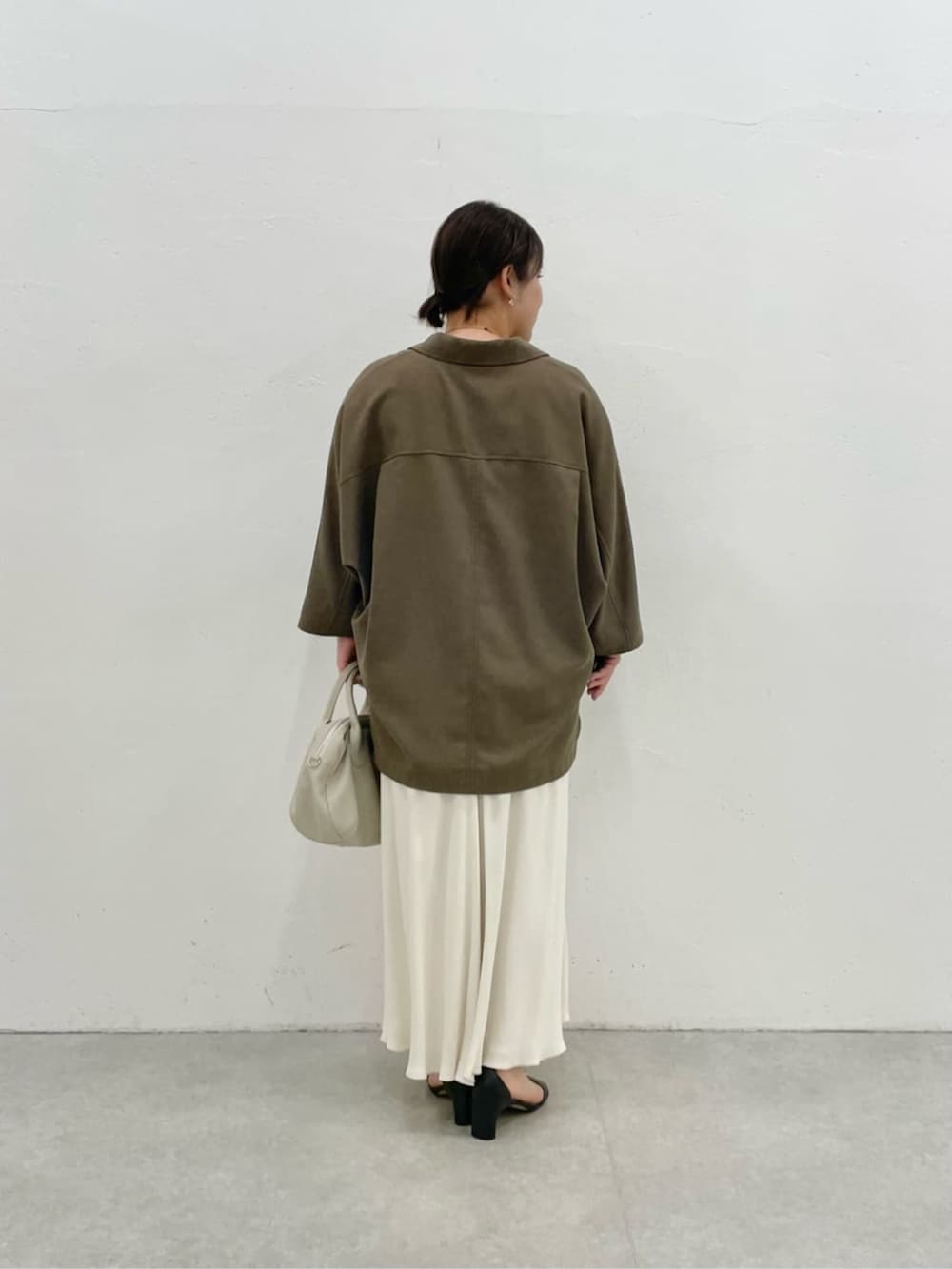 グレー系のボストンバッグ、ブラウン系のテーラードジャケットを着用したレディースの春コーディネートの3枚目の写真