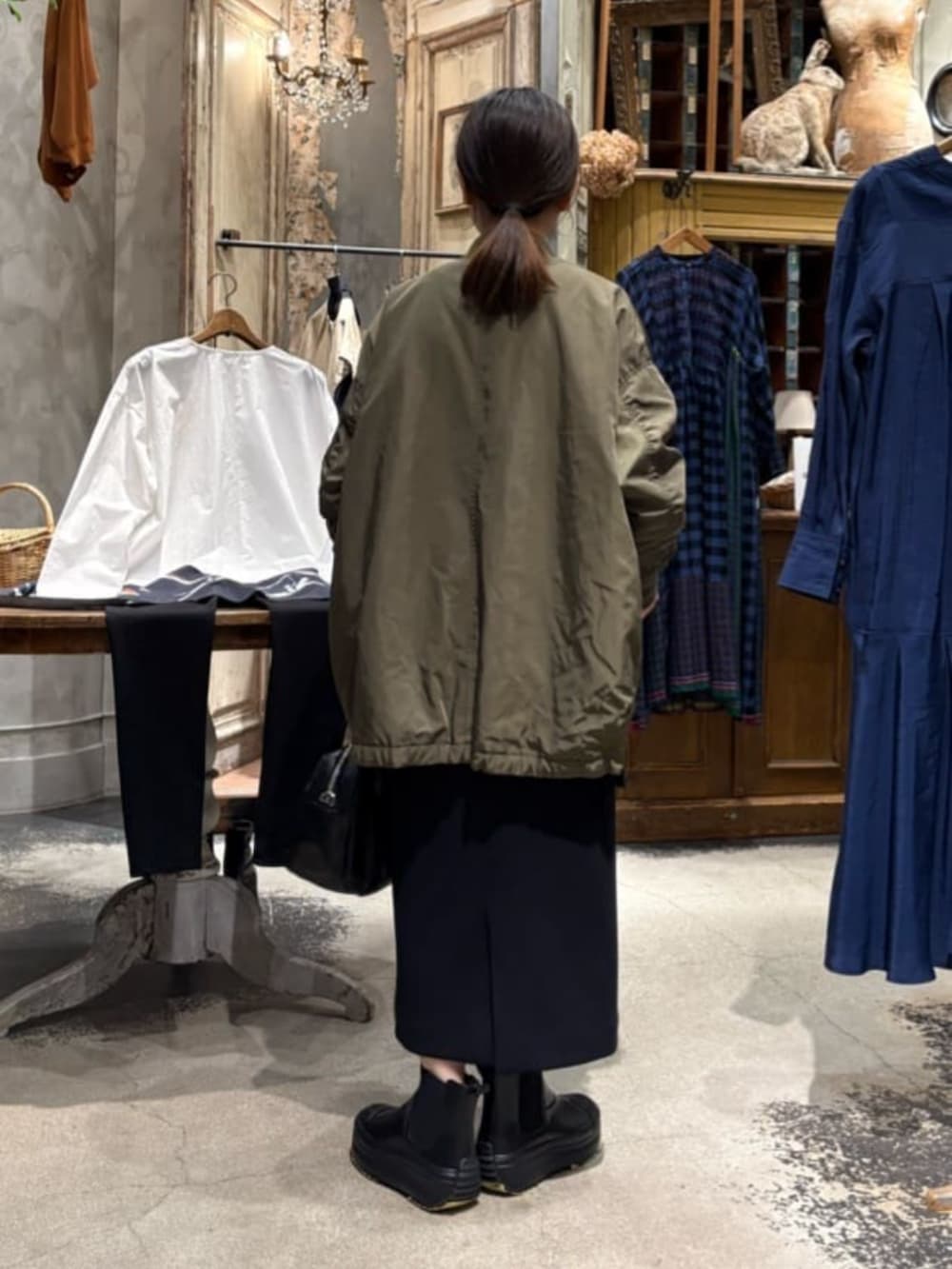 グリーン系のMA-1、ブラック系のブーツ、ブラック系のスカートを着用したレディースの冬コーディネートの8枚目の写真