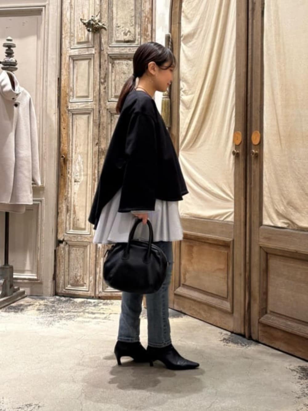 ブルー系のデニムパンツ、ブラック系のTシャツ/カットソーを着用したレディースの冬コーディネートの2枚目の写真