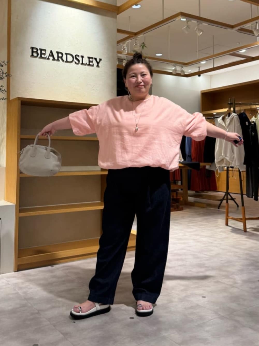 グレー系のボストンバッグ、ピンク系のシャツ/ブラウス、ホワイト系のサンダルを着用したレディースの冬コーディネートの4枚目の写真