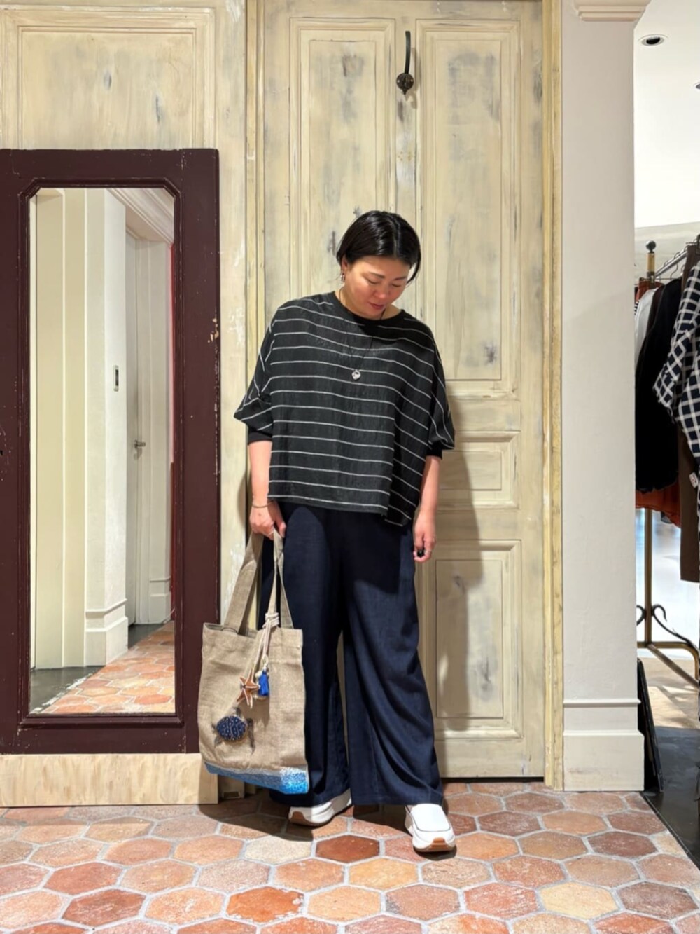 ブルー系のその他パンツ、ブラック系のシャツ/ブラウス、ホワイト系のスニーカーを着用したレディースの春コーディネートの2枚目の写真