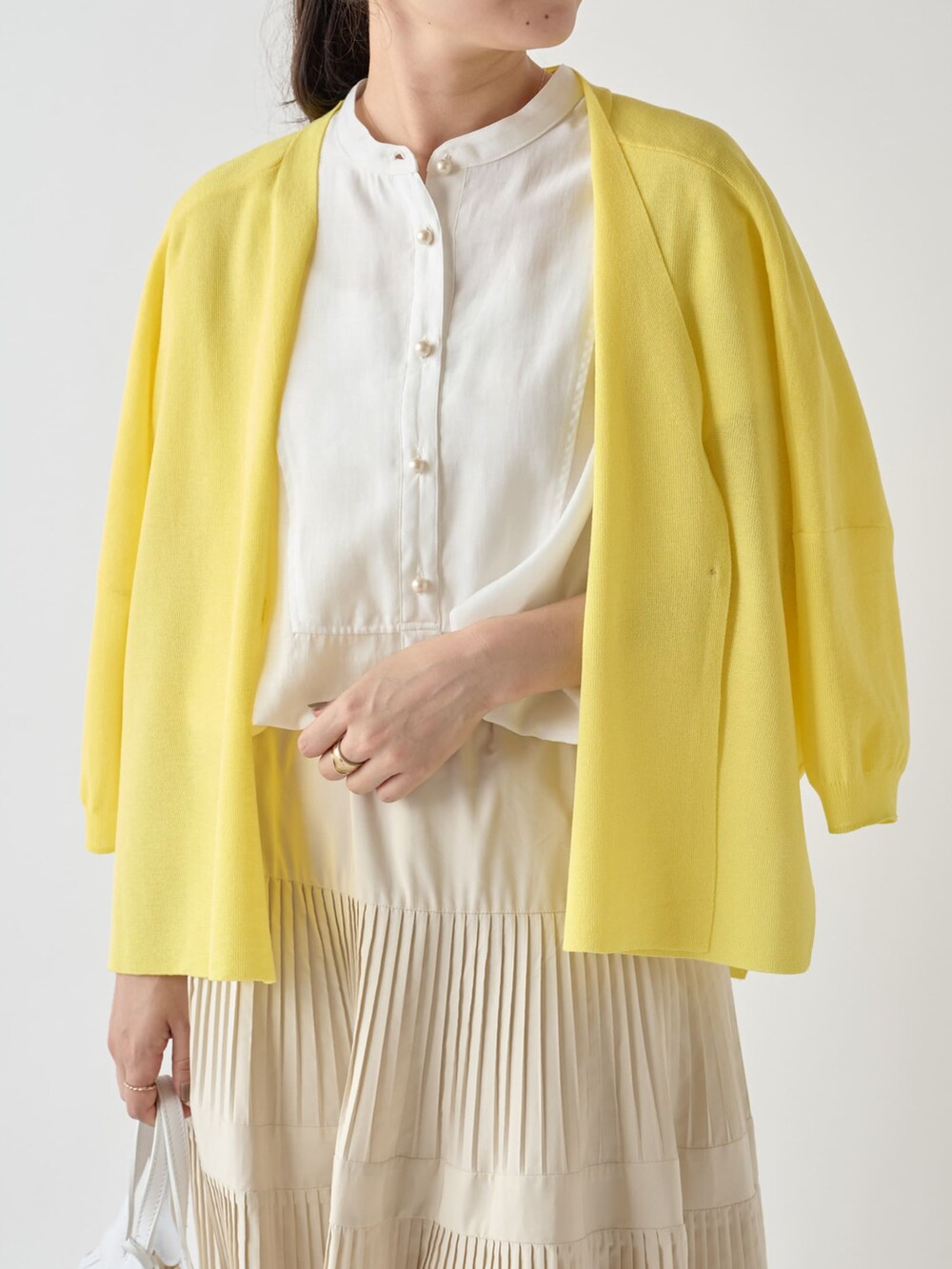 イエロー系のカーディガン/ボレロ、ホワイト系のシャツ/ブラウス、ホワイト系のスカートを着用したレディースの夏コーディネートの2枚目の写真