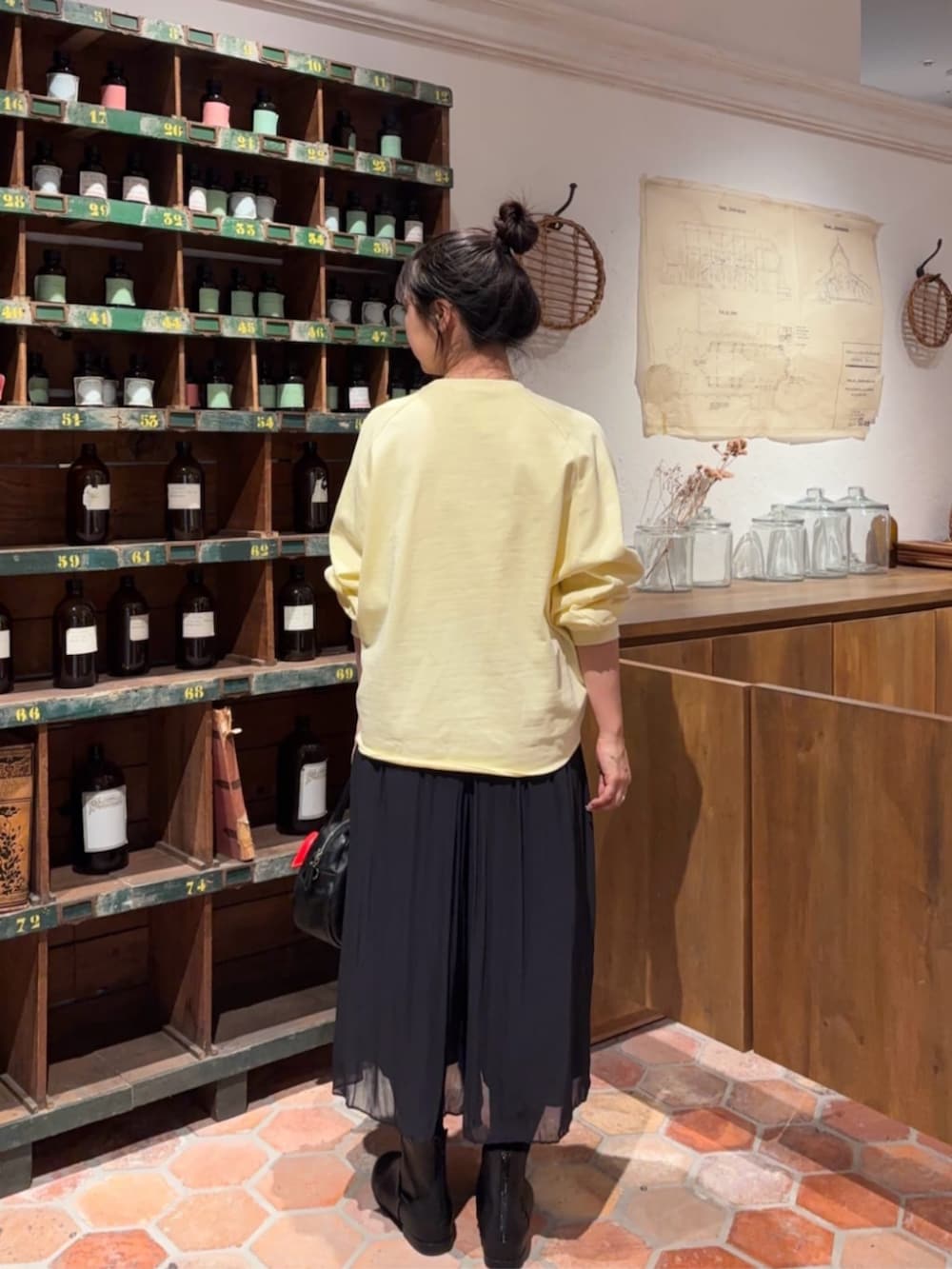 ブラック系のボストンバッグ、ブラック系のその他パンツ、イエロー系のTシャツ/カットソーを着用したレディースの冬コーディネートの4枚目の写真