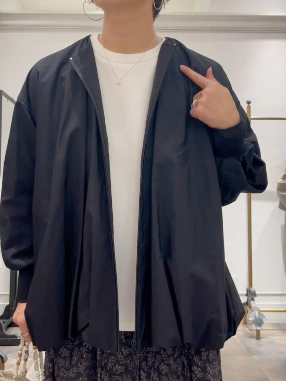 ブラック系のスカート、ベージュ系のショルダーバッグ、ブラック系のブルゾンを着用したレディースの冬コーディネートの5枚目の写真