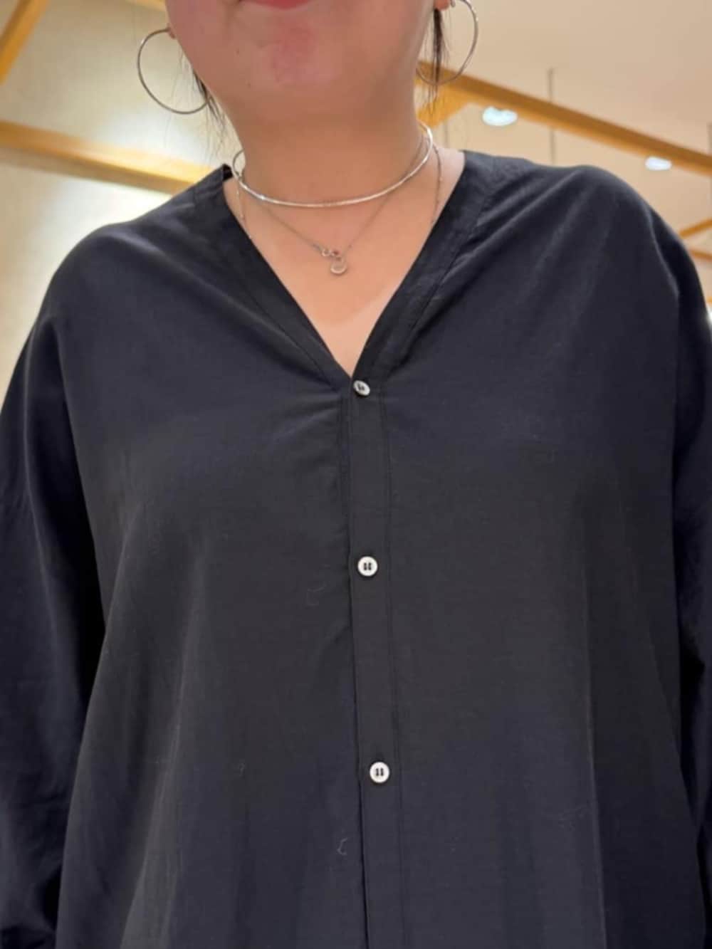 グリーン系のハンドバッグ、ブラック系のワンピースを着用したレディースの冬コーディネートの9枚目の写真