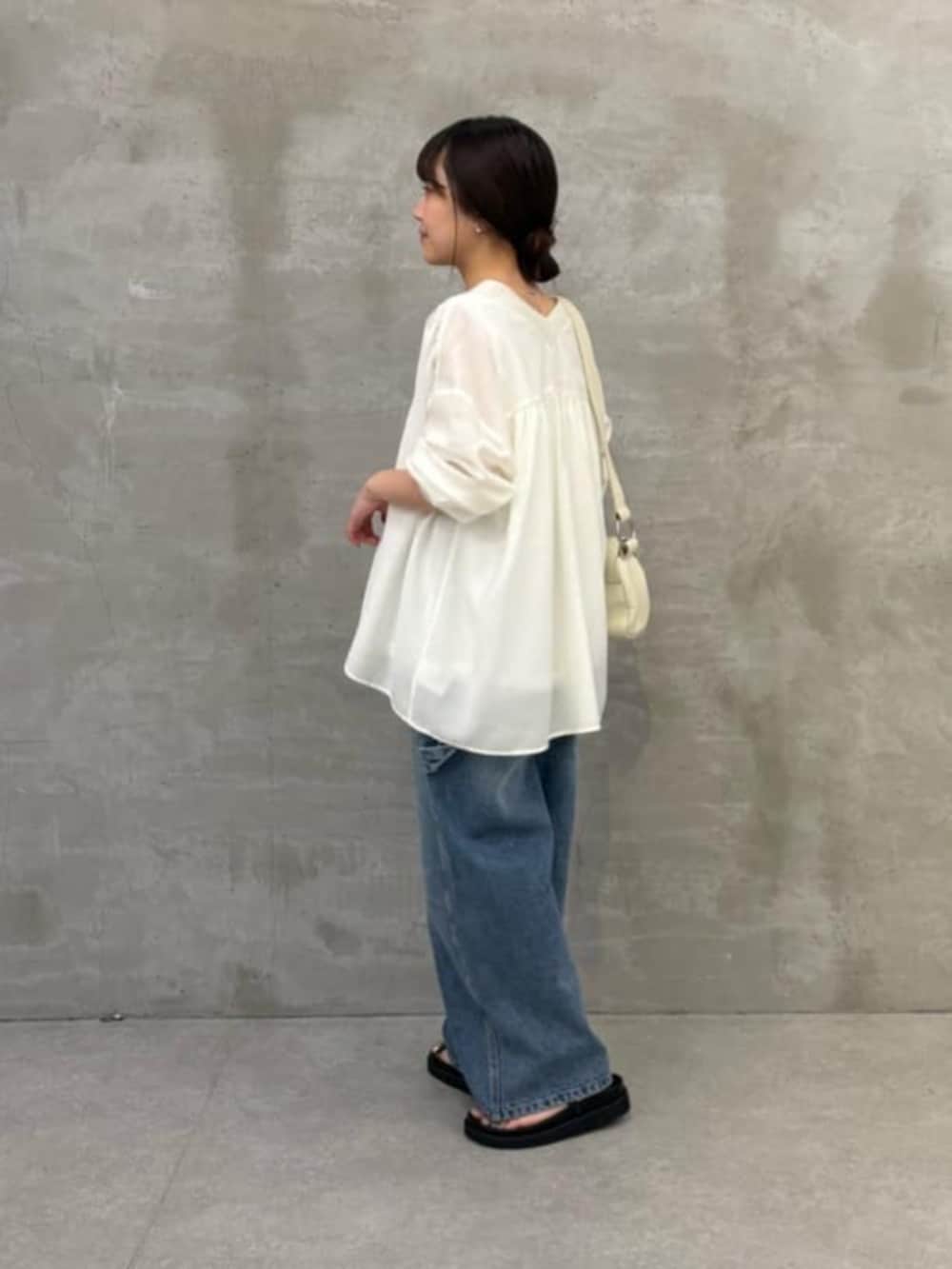 ホワイト系のショルダーバッグ、ブラック系のサンダル、ブルー系のその他パンツを着用したレディースの冬コーディネートの4枚目の写真