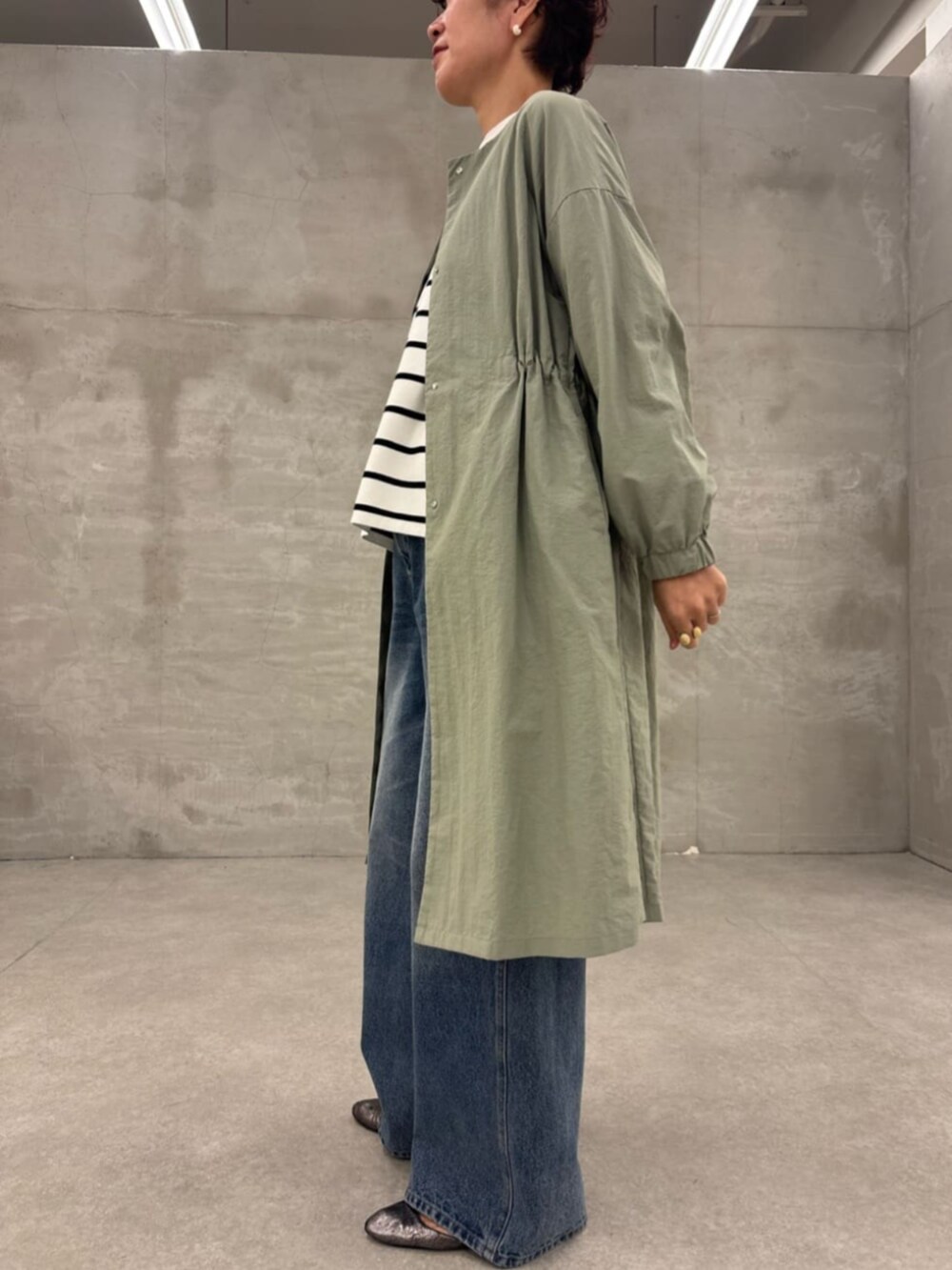 ブラック系のショルダーバッグ、グリーン系のその他アウター、ホワイト系のニット/セーターを着用したレディースの冬コーディネートの3枚目の写真