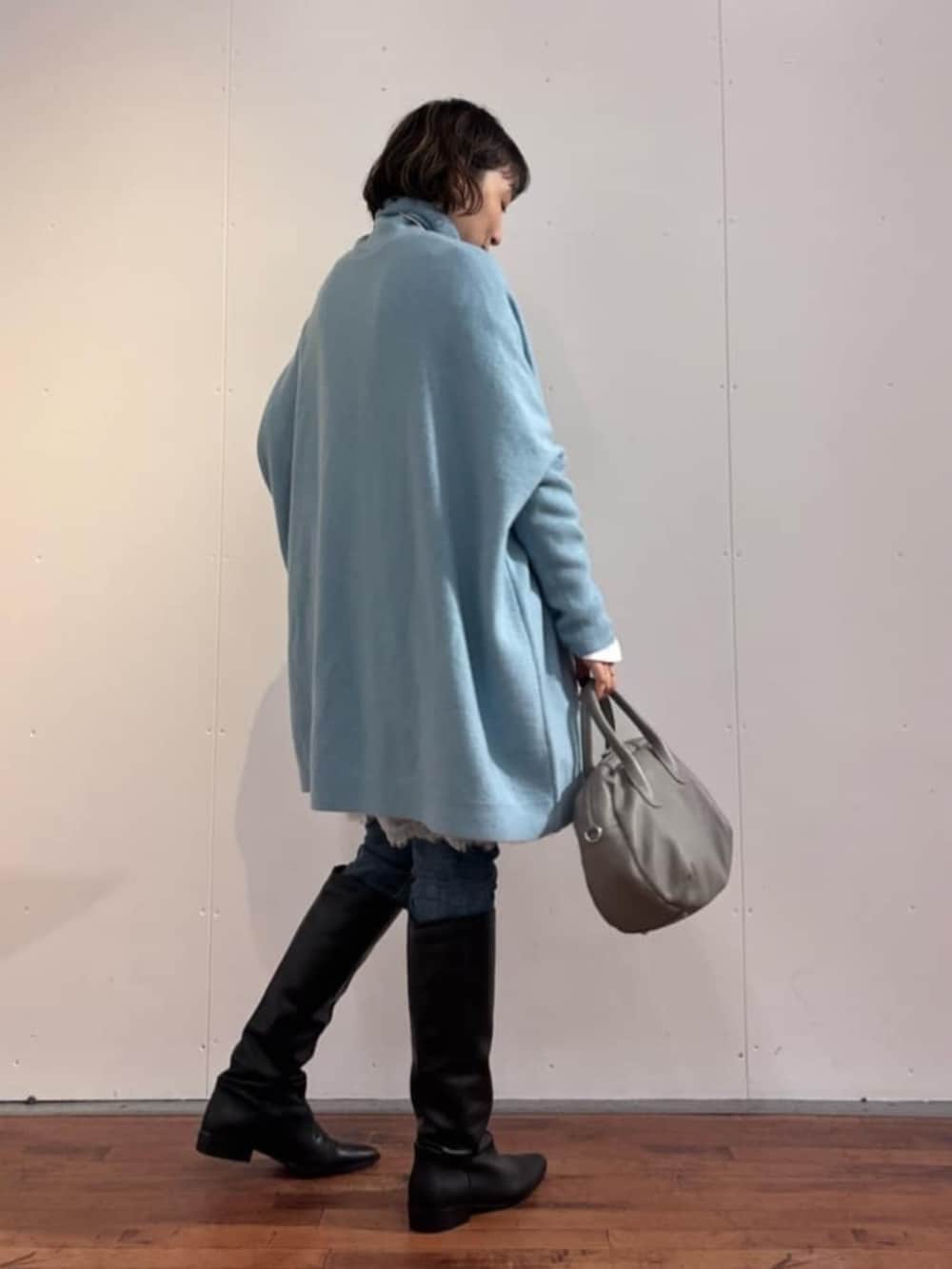 ブルー系のデニムパンツ、グレー系のトートバッグ、ホワイト系のTシャツ/カットソーを着用したレディースの秋コーディネートの4枚目の写真