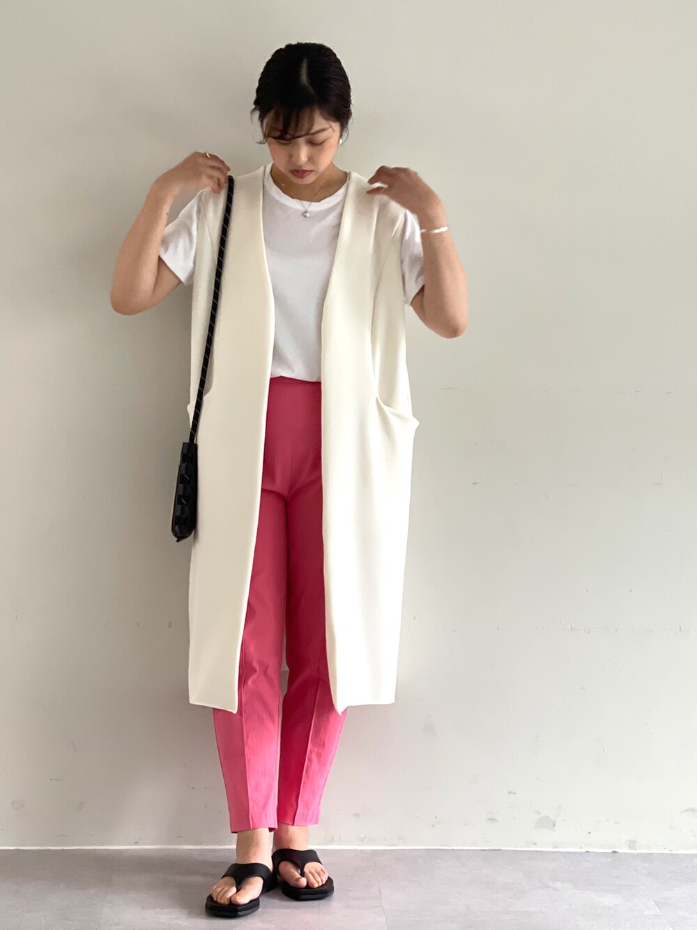 ホワイト系のベスト、ピンク系のその他パンツを着用したレディースの夏コーディネートの3枚目の写真