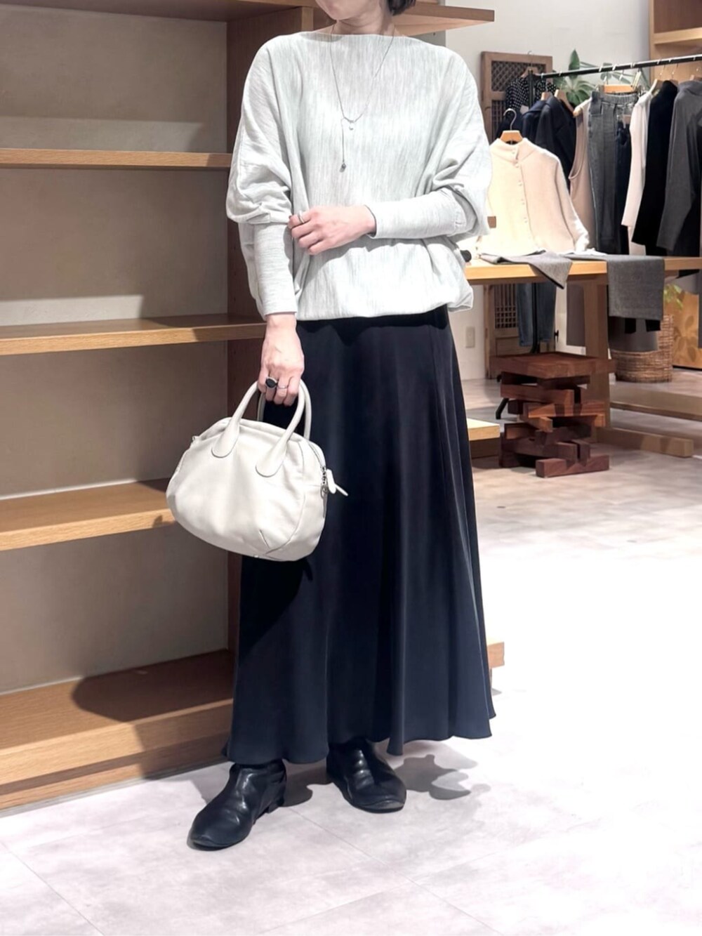 ブラック系のスカート、グレー系のボストンバッグ、グレー系のニット/セーターを着用したレディースの冬コーディネートの4枚目の写真