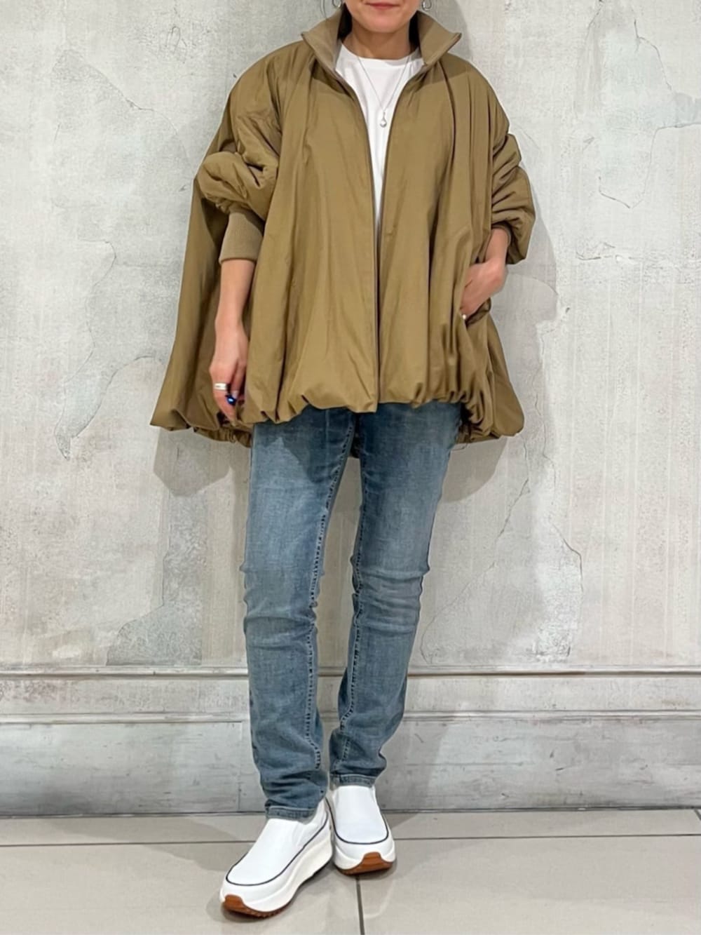 ホワイト系のスニーカー、ブルー系のデニムパンツ、イエロー系のその他アウターを着用したレディースの冬コーディネートの7枚目の写真