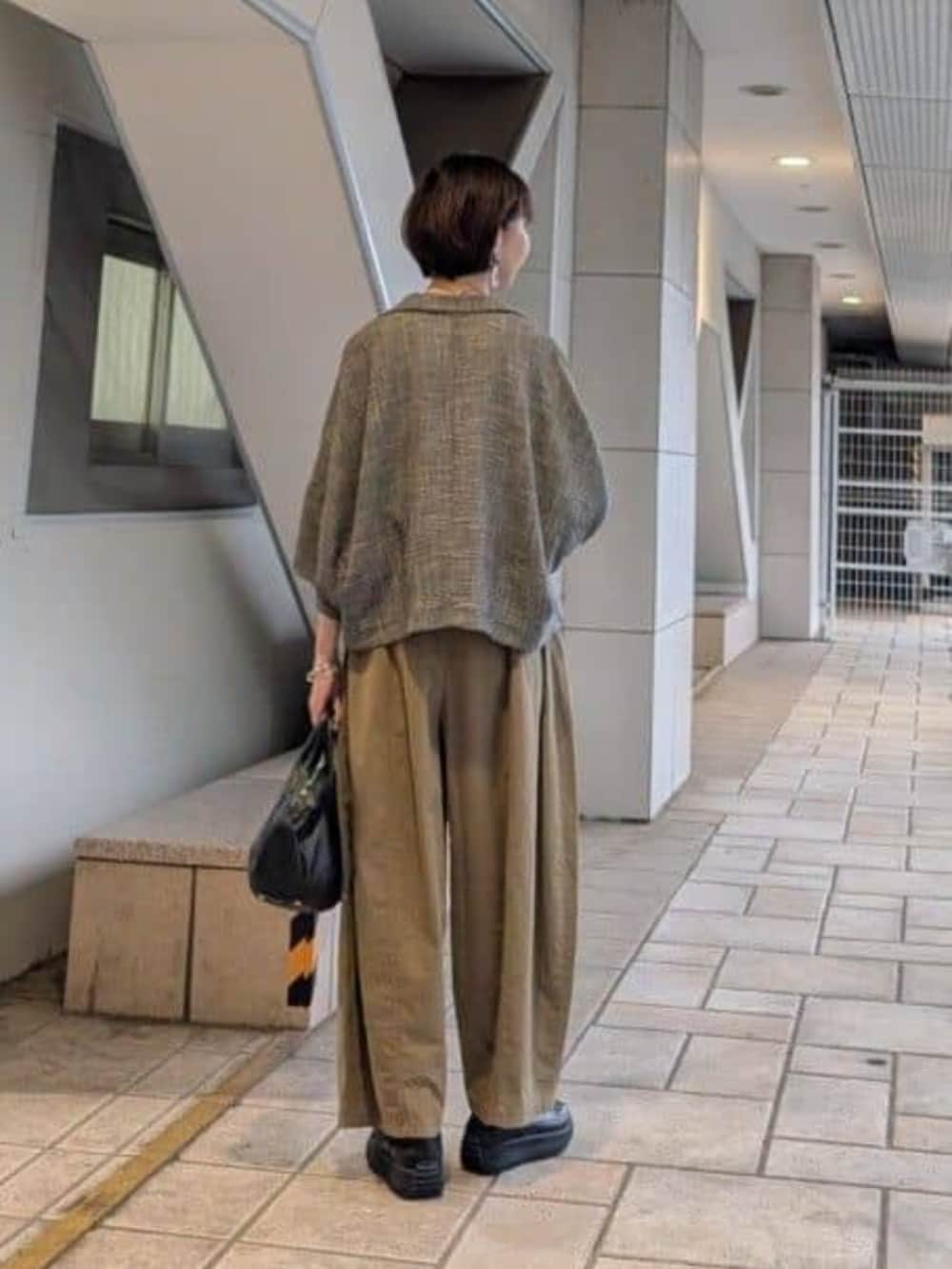 ブラック系のボストンバッグ、イエロー系のその他パンツ、ベージュ系のテーラードジャケットを着用したレディースの夏コーディネートの3枚目の写真