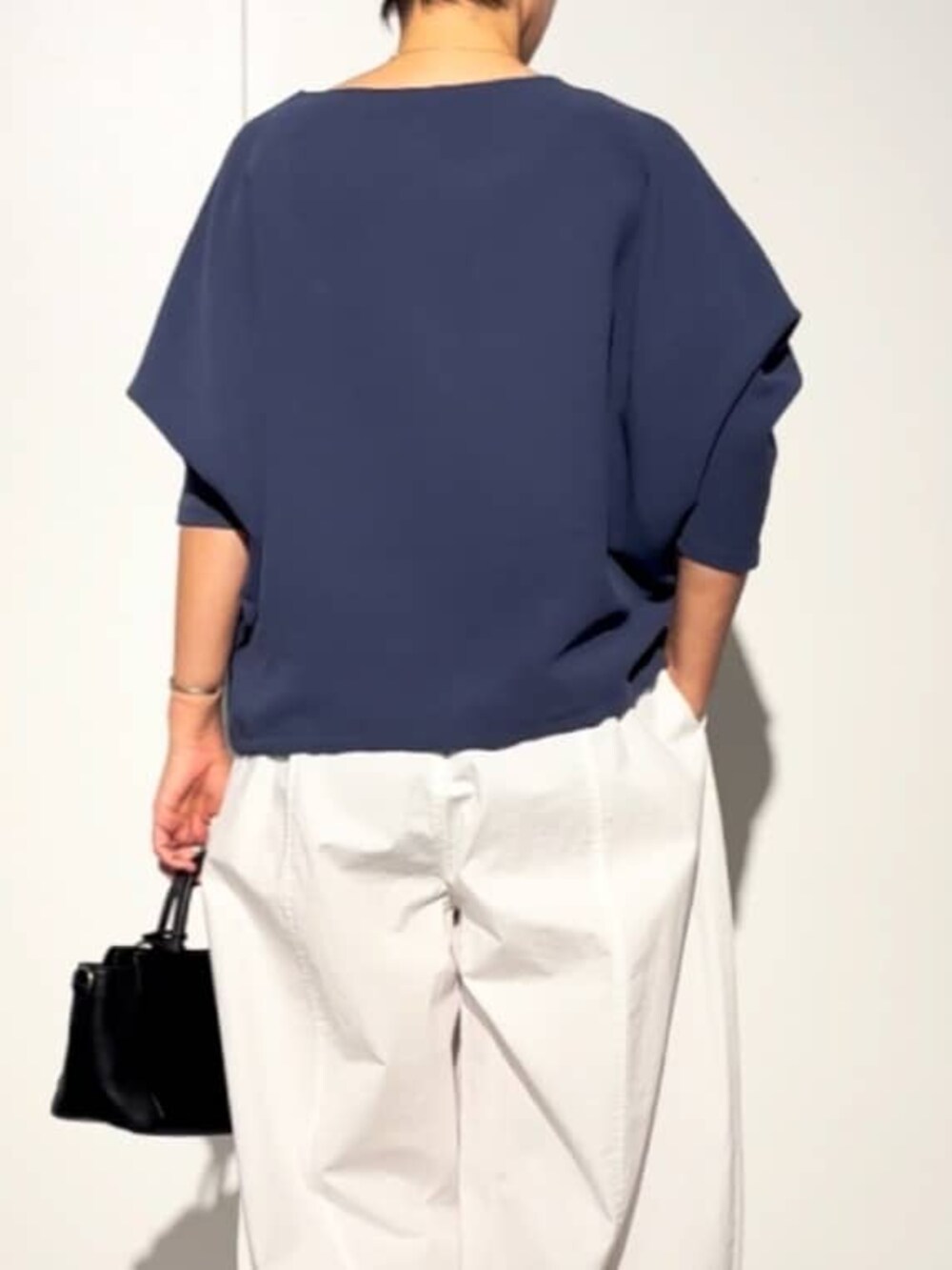 ブラック系のハンドバッグ、ブルー系のシャツ/ブラウス、ホワイト系のその他パンツを着用したレディースの春コーディネートの8枚目の写真