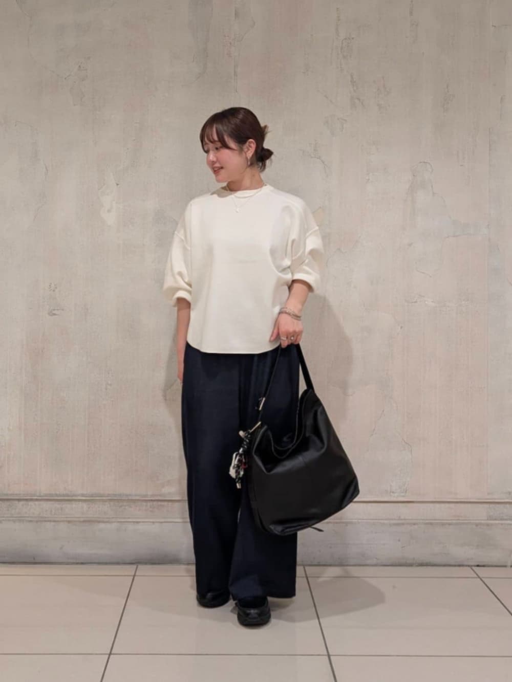 ブルー系のその他パンツ、ブラック系のショルダーバッグ、ホワイト系のTシャツ/カットソーを着用したレディースの春コーディネートの5枚目の写真