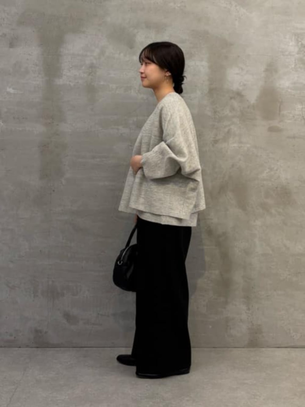 ブラック系のボストンバッグ、グレー系のニット/セーター、グレー系のカーディガン/ボレロを着用したレディースの春コーディネートの6枚目の写真