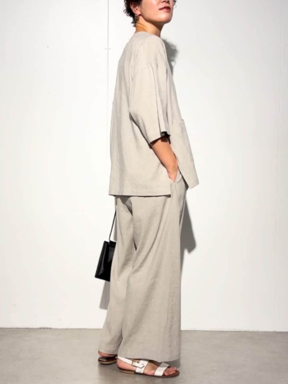 ブラック系のショルダーバッグ、ベージュ系のその他パンツ、ベージュ系のその他アウターを着用したレディースの春コーディネートの4枚目の写真