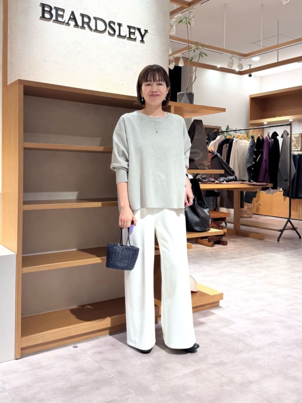 ホワイト系のその他パンツ、ブルー系のハンドバッグ、グレー系のニット/セーターを着用したレディースの冬コーディネートの4枚目の写真