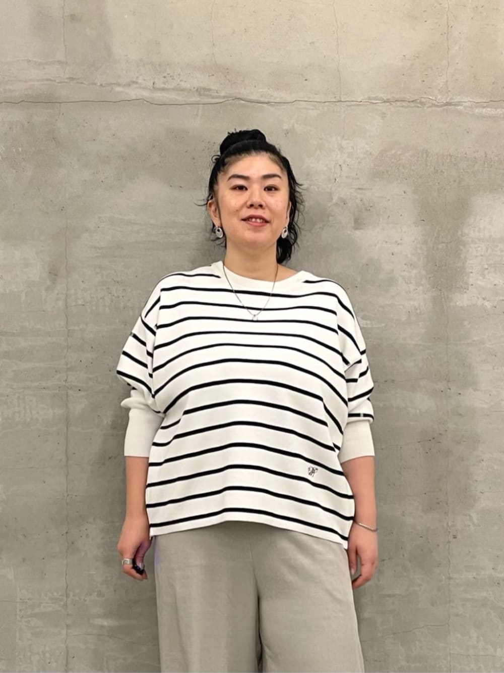 ブラック系のショルダーバッグ、ホワイト系のニット/セーター、ホワイト系のサンダルを着用したレディースの冬コーディネートの5枚目の写真