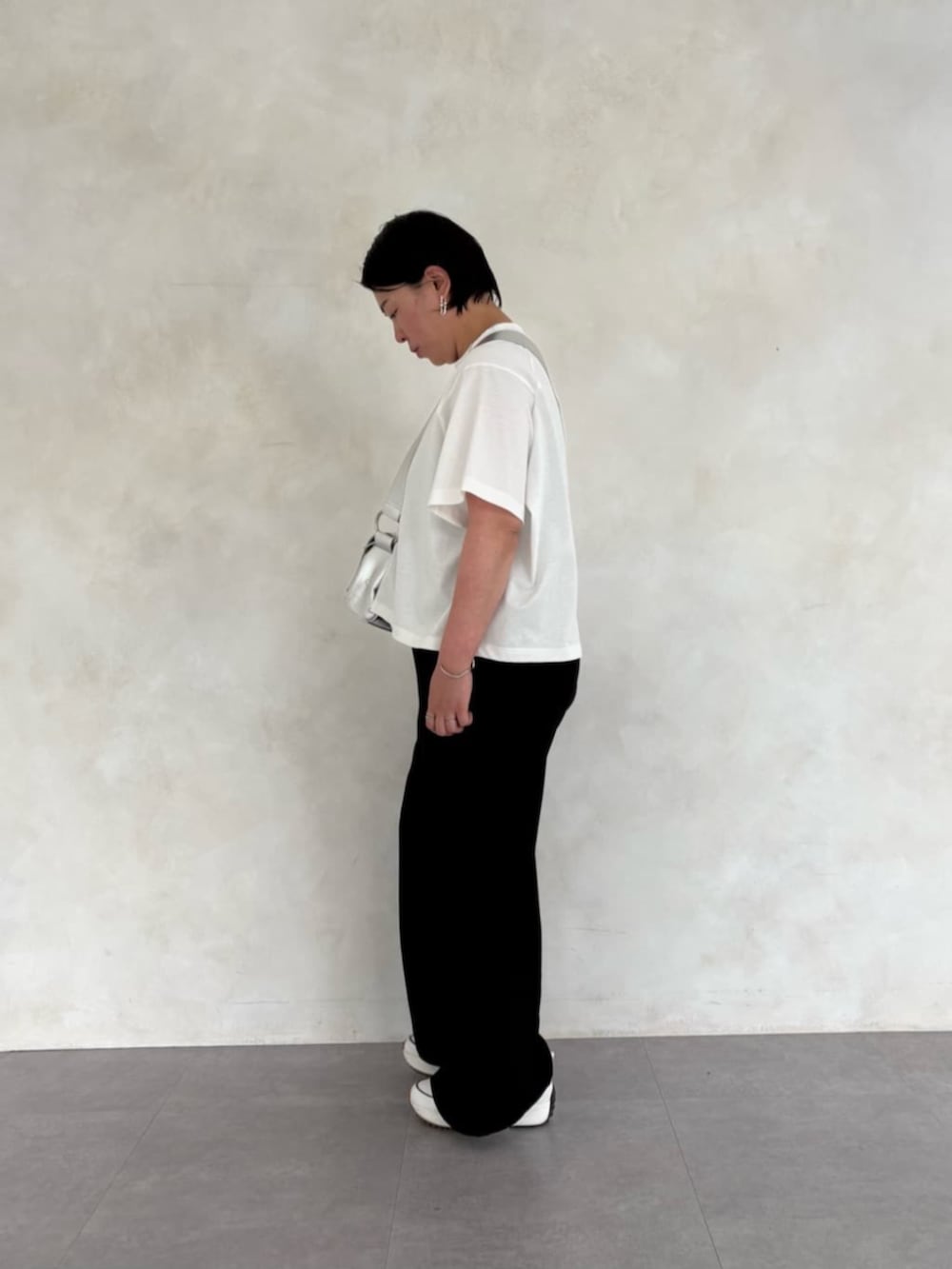 シルバー系のショルダーバッグ、ホワイト系のTシャツ/カットソー、ホワイト系のスニーカーを着用したレディースの春コーディネートの3枚目の写真