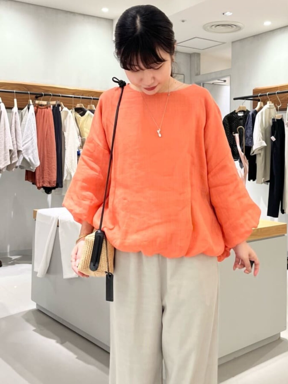 グレー系のその他パンツ、オレンジ系のシャツ/ブラウスを着用したレディースの春コーディネートの6枚目の写真