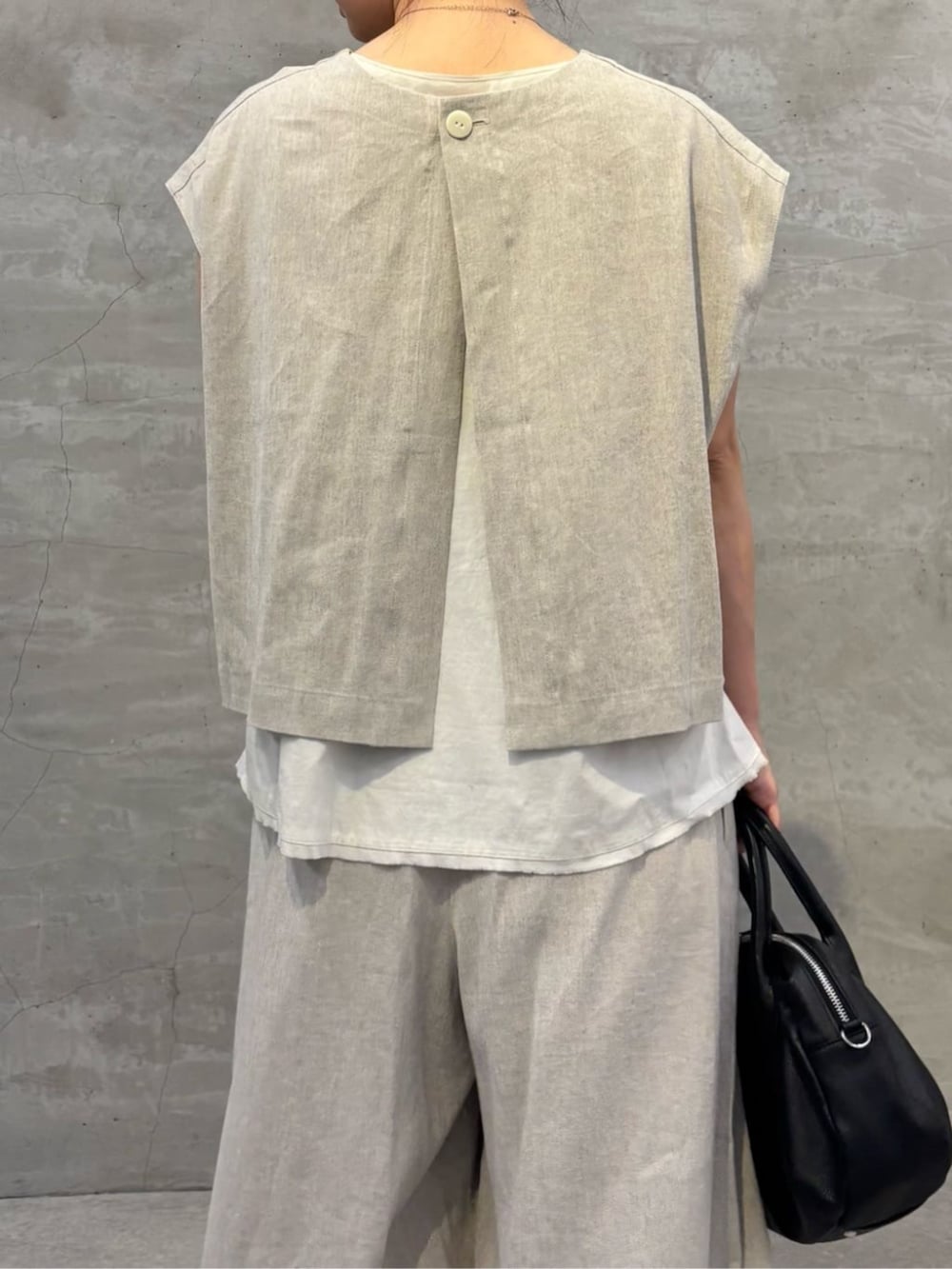 ブラック系のボストンバッグ、ホワイト系のサンダル、ホワイト系のシャツ/ブラウスを着用したレディースの春コーディネートの5枚目の写真