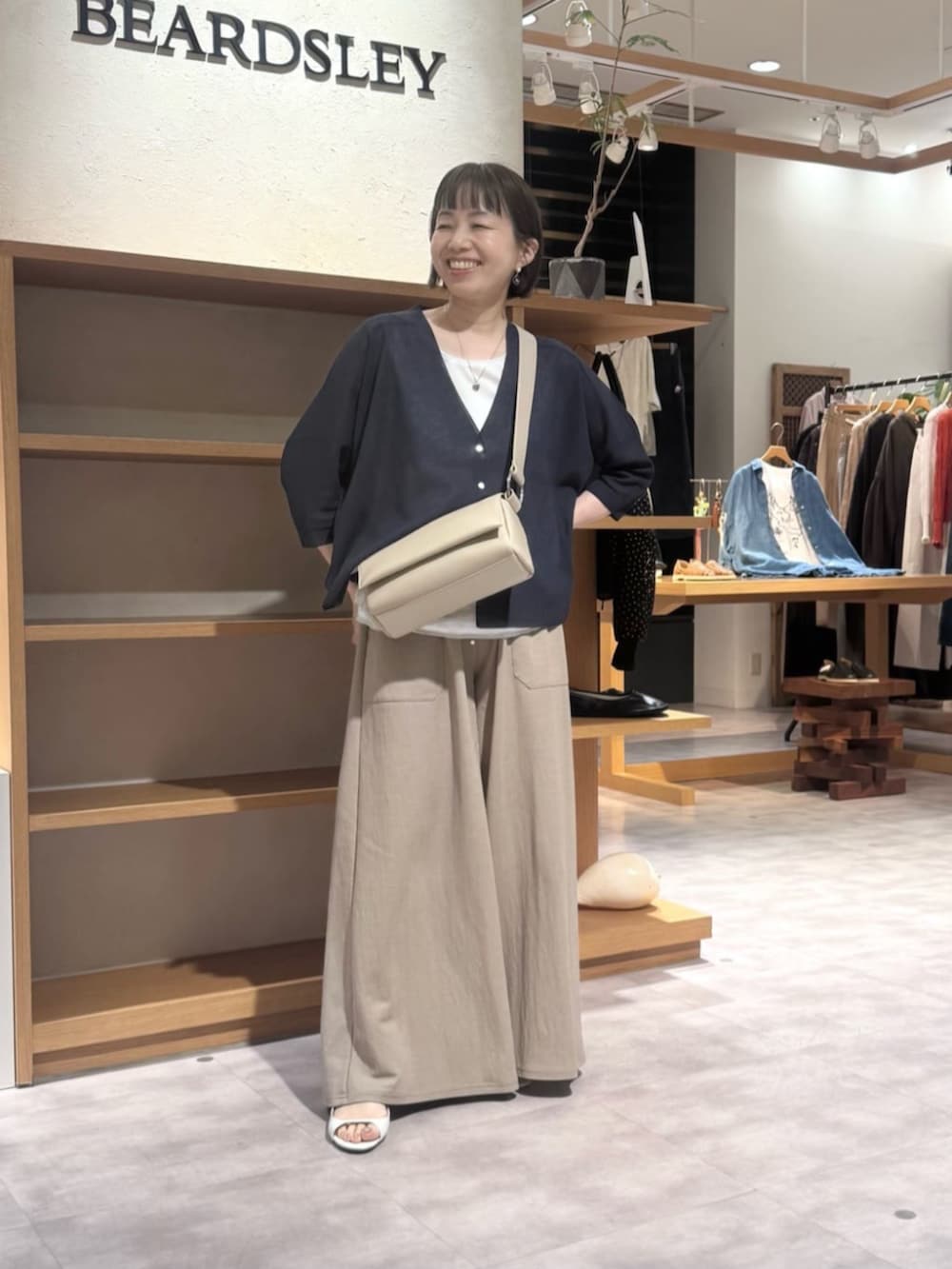 ベージュ系のその他パンツ、ベージュ系のショルダーバッグ、ブルー系のカーディガン/ボレロを着用したレディースの春コーディネートの6枚目の写真