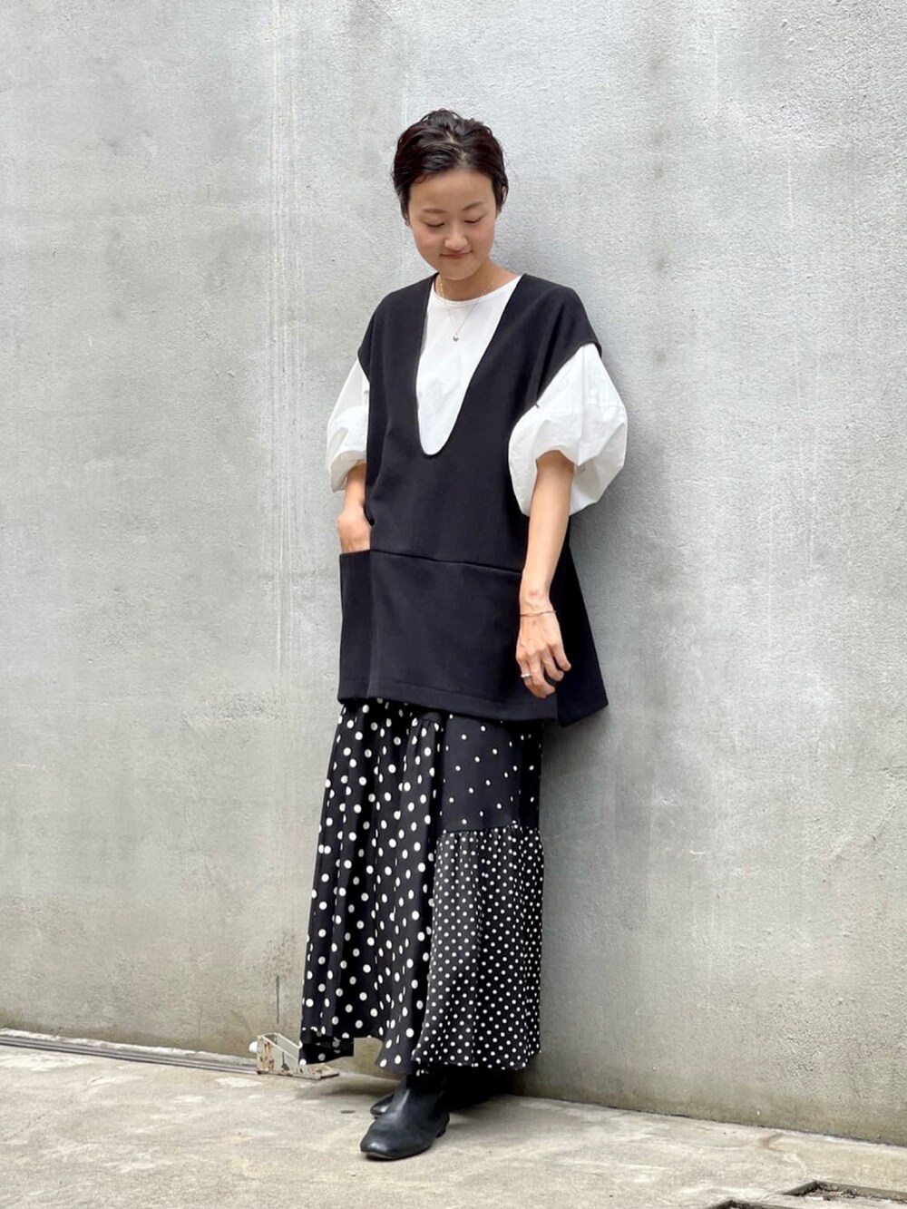 ブラック系のスカート、ホワイト系のシャツ/ブラウス、ブラック系のブーツを着用したレディースの夏コーディネートの4枚目の写真