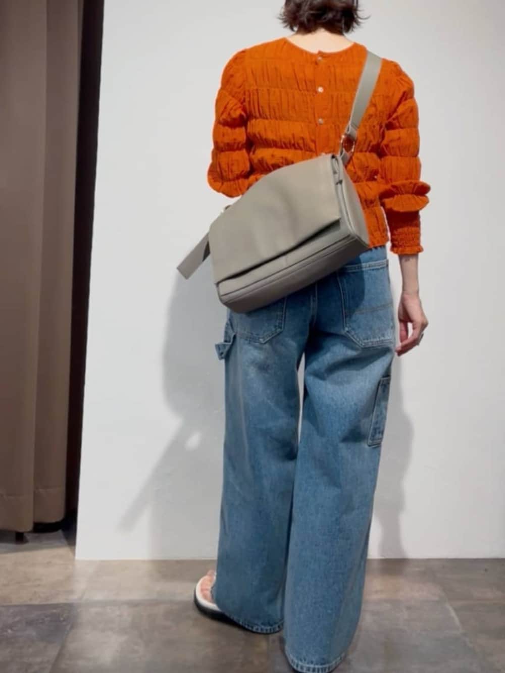 オレンジ系のシャツ/ブラウス、ブルー系のその他パンツ、ホワイト系のサンダルを着用したレディースの春コーディネートの5枚目の写真