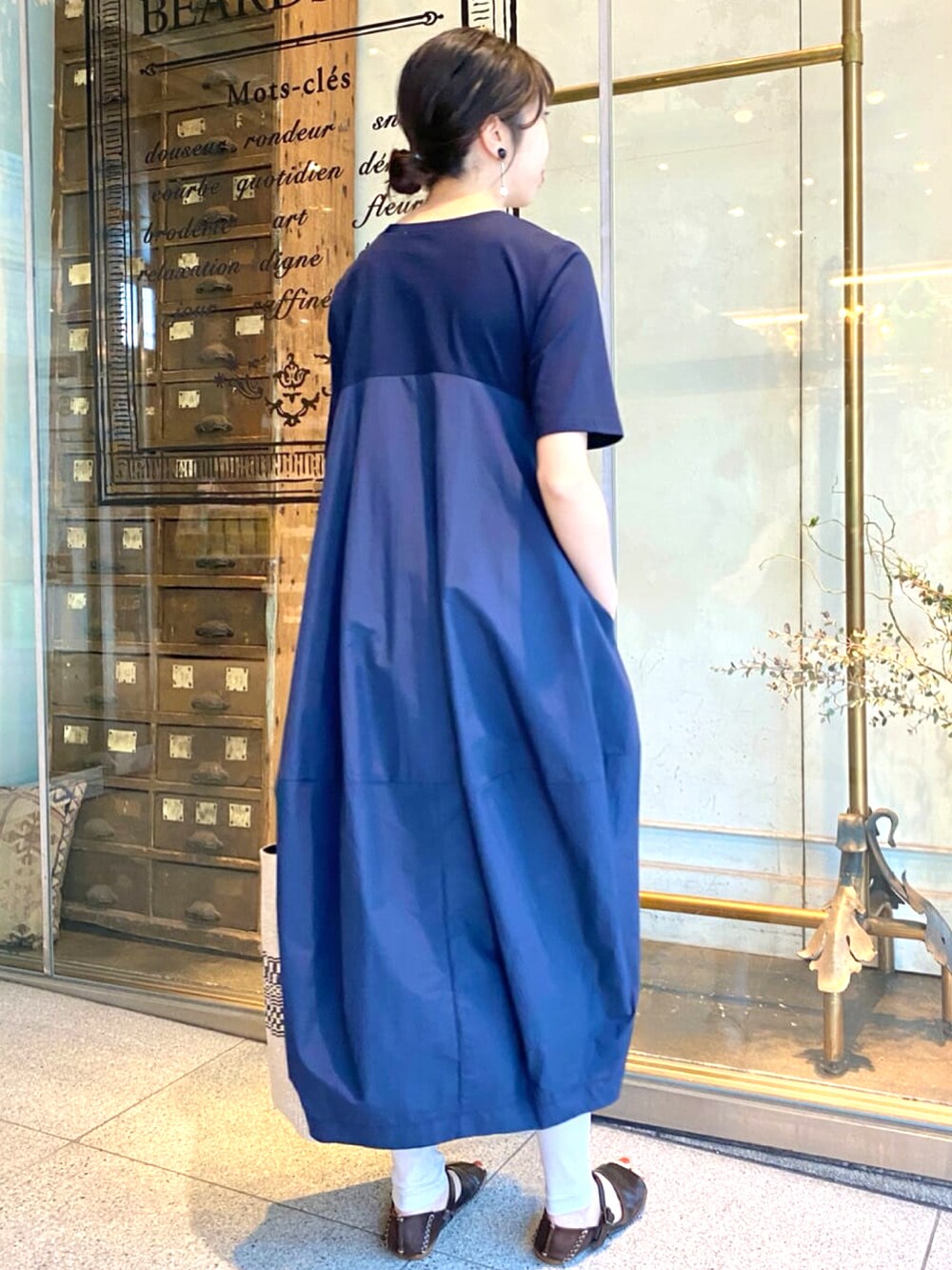 ブルー系のワンピース、グレー系のその他パンツ、ブラック系のトートバッグを着用したレディースの春コーディネートの3枚目の写真