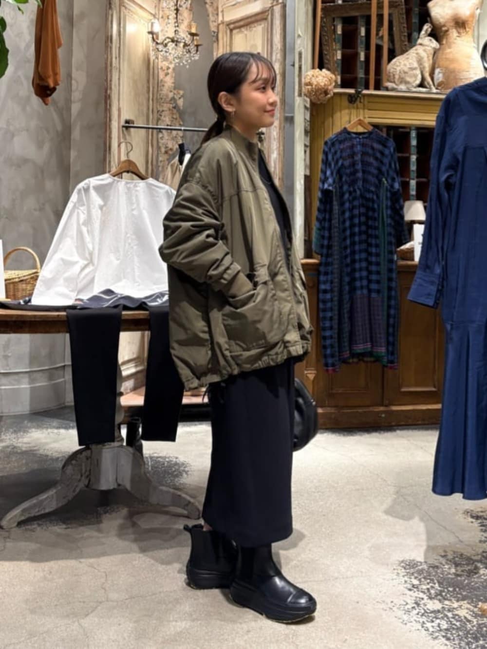 グリーン系のMA-1、ブラック系のスカートを着用したレディースの冬コーディネートの4枚目の写真