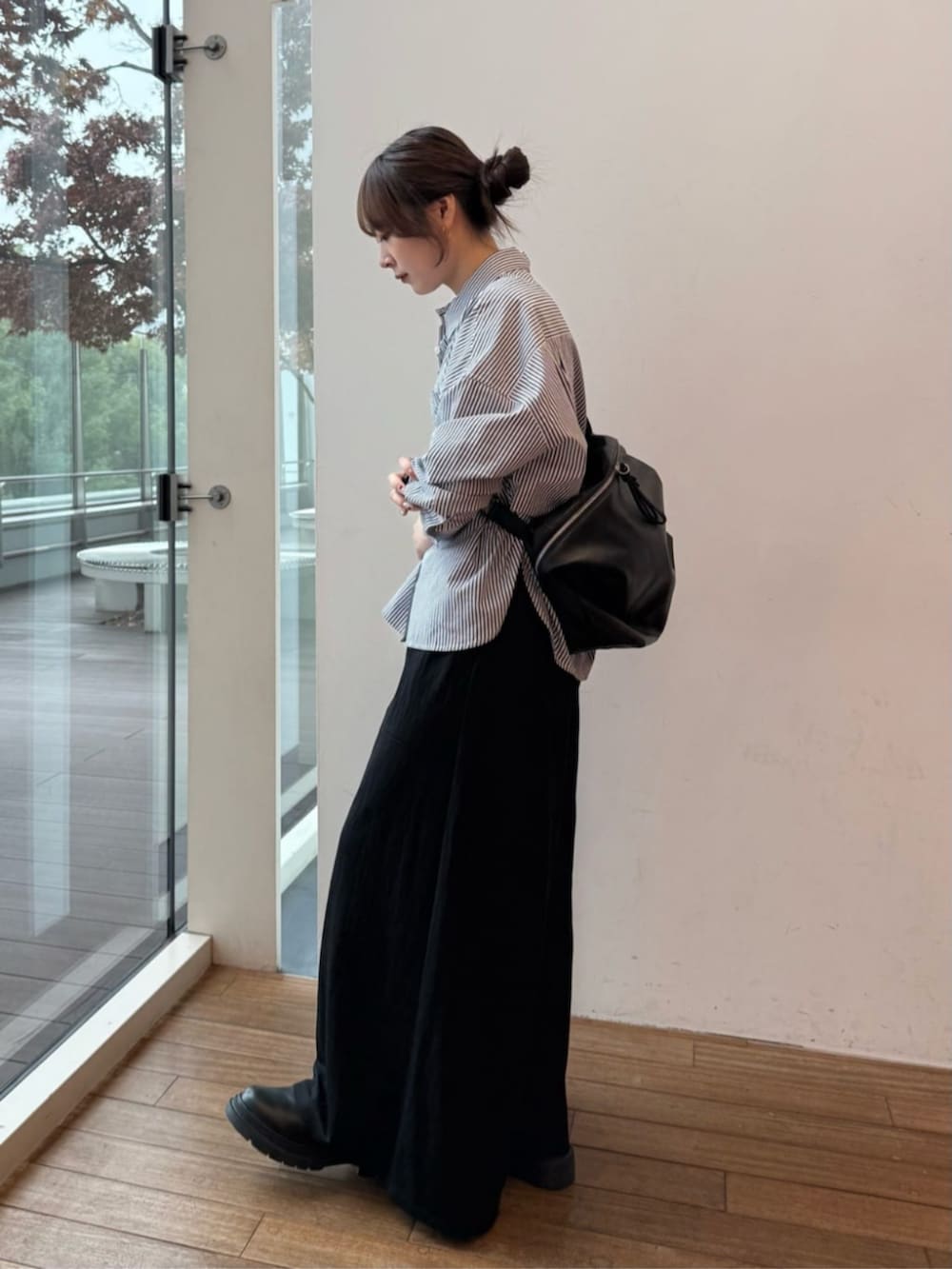 ブラック系のショルダーバッグ、ブルー系のシャツ/ブラウス、ブラック系のその他パンツを着用したレディースの冬コーディネートの2枚目の写真