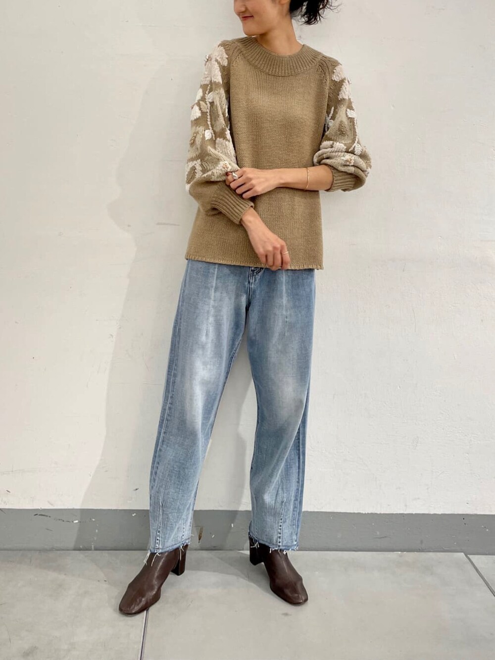 ベージュ系のニット/セーターを着用したレディースの夏コーディネートの2枚目の写真