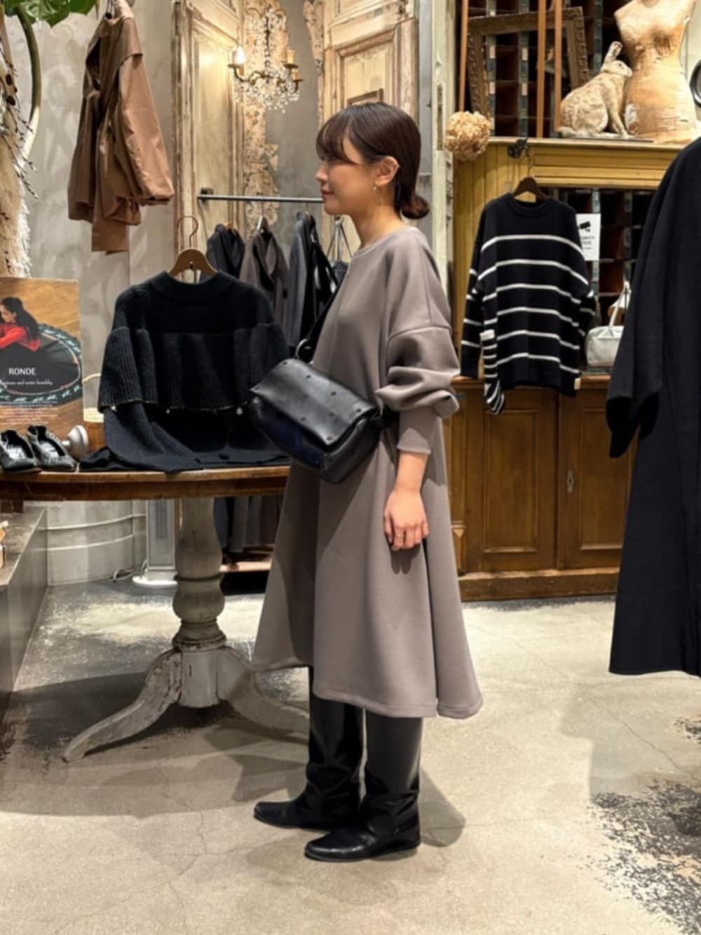 ブラウン系のワンピース、ブラック系のショルダーバッグ、シルバー系のネックレスを着用したレディースの冬コーディネートの4枚目の写真