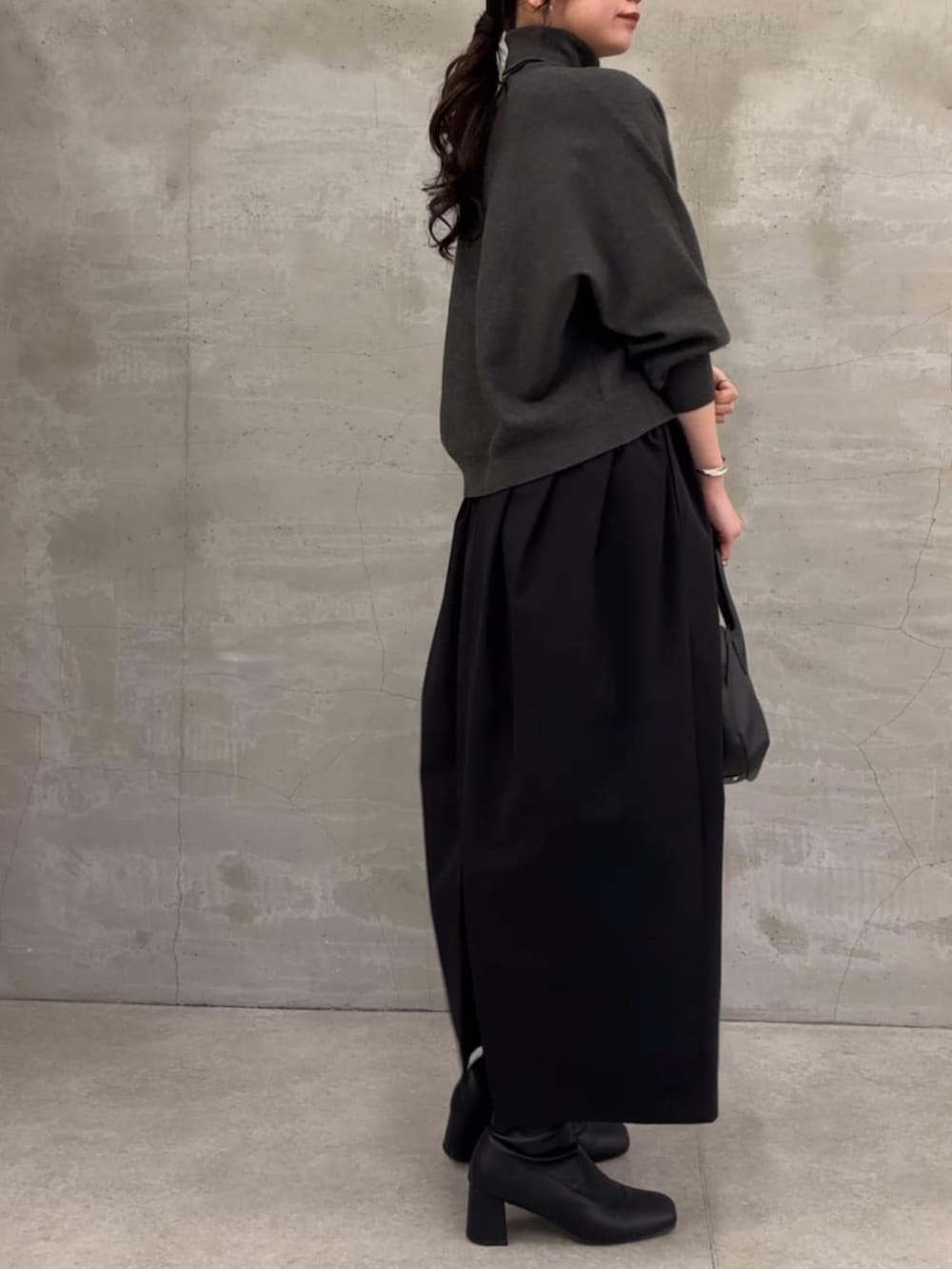 グレー系のニット/セーター、ブラック系のスカートを着用したレディースの冬コーディネートの6枚目の写真