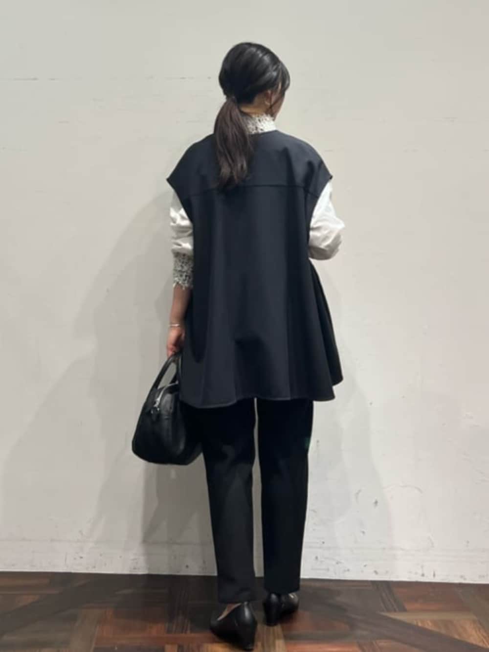 ブラック系のベスト、ブラック系のその他パンツ、ホワイト系のシャツ/ブラウスを着用したレディースの冬コーディネートの4枚目の写真