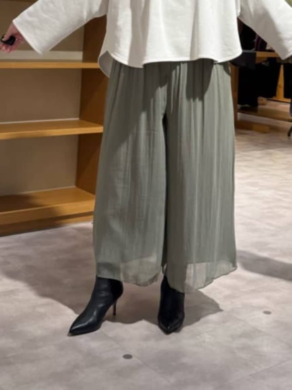 グリーン系のその他パンツ、ブラック系のブーツ、ブラック系のトートバッグを着用したレディースの冬コーディネートの7枚目の写真