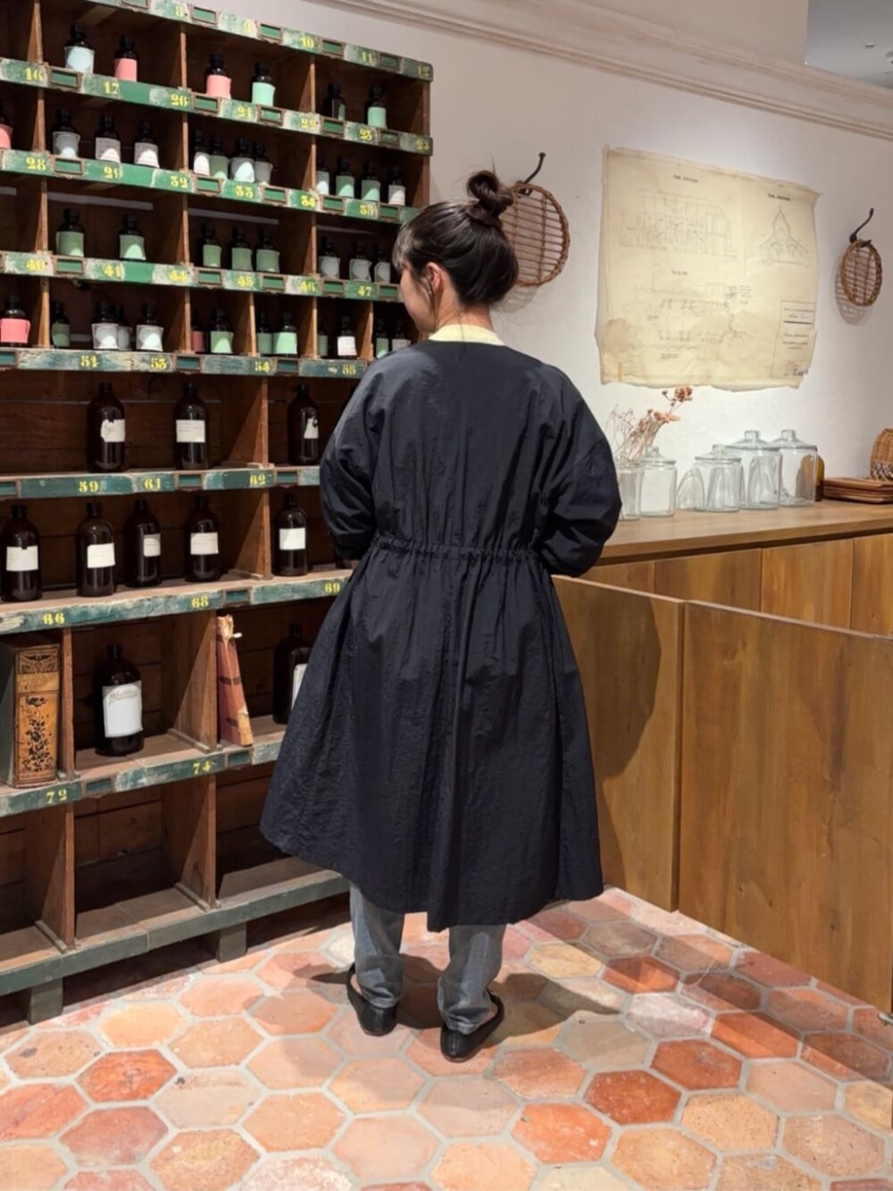 ブルー系のデニムパンツ、ブラック系のボストンバッグ、イエロー系のTシャツ/カットソーを着用したレディースの冬コーディネートの3枚目の写真