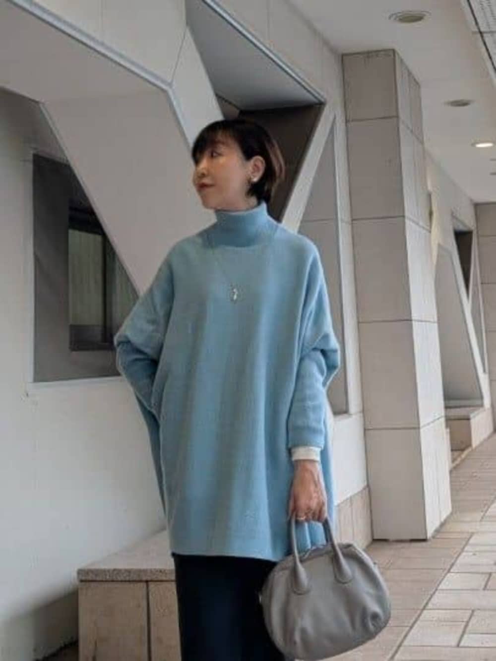 ブラック系のその他パンツ、グレー系のトートバッグ、グリーン系のニット/セーターを着用したレディースの秋コーディネートの2枚目の写真