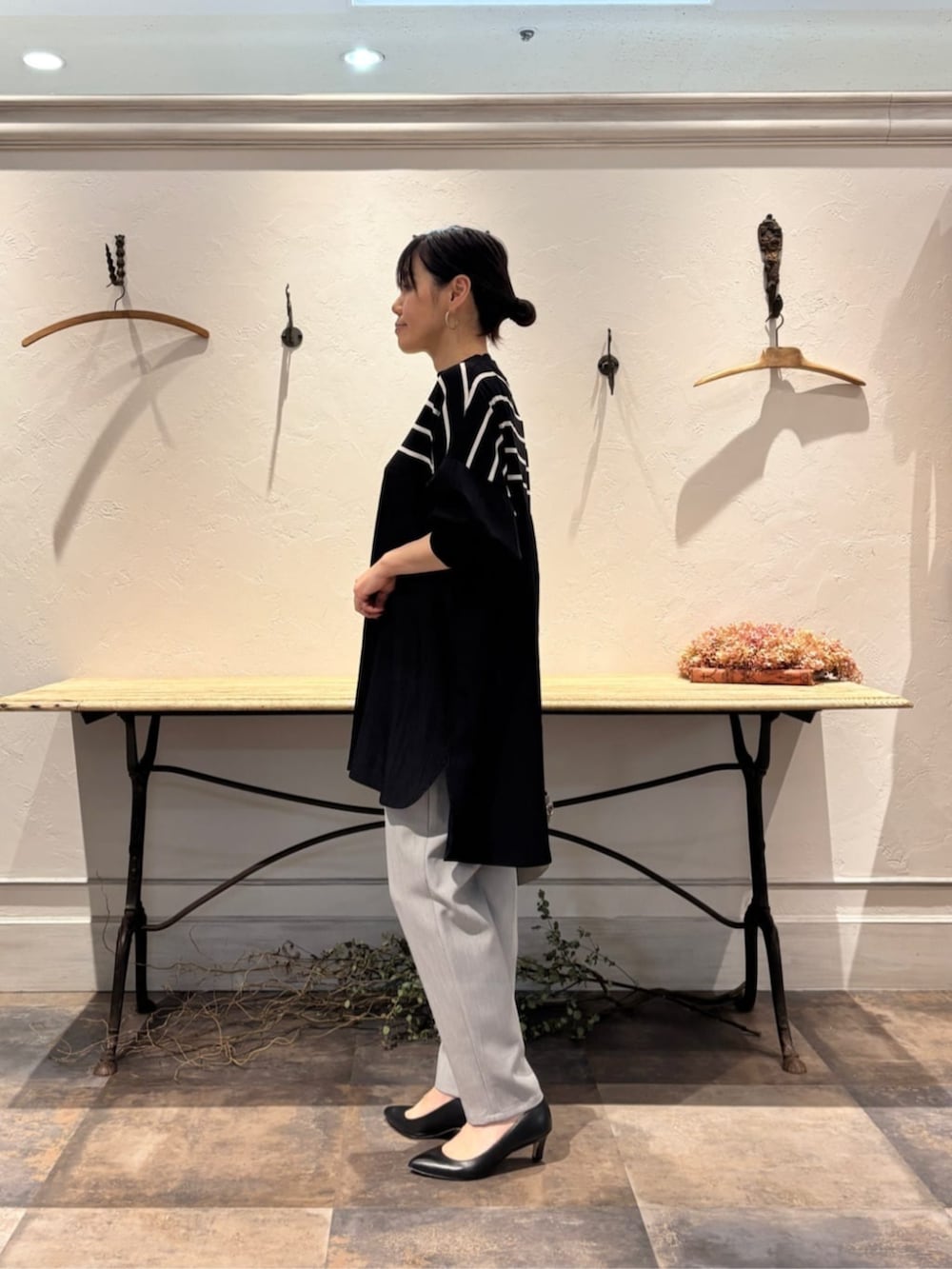 グレー系のその他パンツ、ブラック系のニット/セーター、シルバー系のネックレスを着用したレディースの冬コーディネートの2枚目の写真