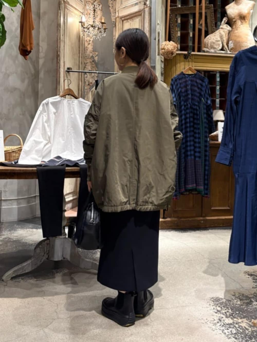 グリーン系のMA-1、ブラック系のブーツ、ブラック系のスカートを着用したレディースの冬コーディネートの6枚目の写真